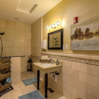 A well-designed bathroom featuring a modern sink, mirror, and tiled shower area.