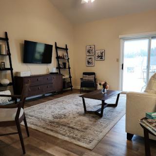 A cozy living room featuring a television, stylish shelving units, and comfortable seating.
