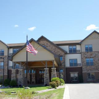 A residential building featuring an American flag in front under a clear blue sky.