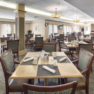 A spacious dining area with neatly arranged tables and chairs, ready for guests.