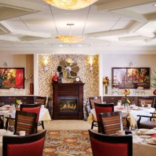 Elegant restaurant interior with a cozy fireplace and beautifully set tables.
