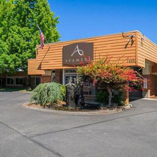 Front view of a building entrance with landscaping and signage.