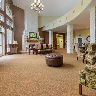 A spacious and elegantly designed lobby with comfortable seating, large windows, and a chandelier.