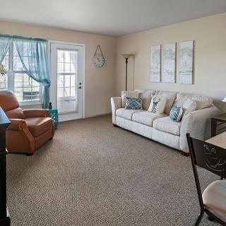 A cozy living room with a sofa, armchair, and decorative elements.