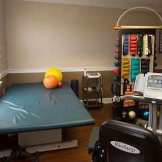 A physical therapy room equipped with a therapy table and various exercise equipment.