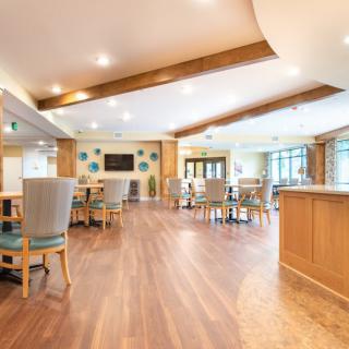 A spacious and modern dining area with wooden flooring and ample lighting.
