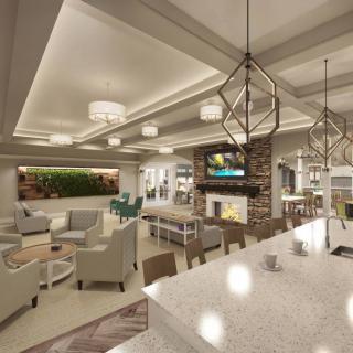 A modern and luxurious living room featuring comfortable seating, elegant lighting, a TV, and a fireplace.