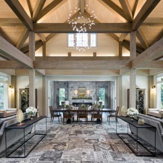 A luxurious and spacious living room with wooden beams and a decorative chandelier.