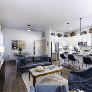 A modern open floor plan featuring a stylish living room and kitchen with contemporary furnishings.