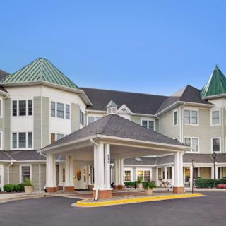 A modern residential building with a covered entrance and distinctive roof design.
