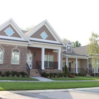 A suburban house with a brick exterior and a well-maintained lawn.