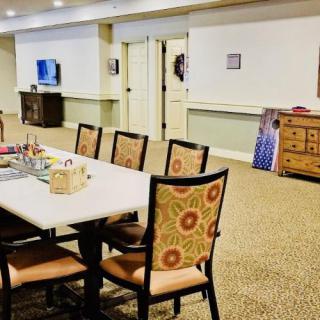 A meeting room with a table and several chairs, a television, and decorative elements.