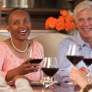 A group of friends enjoying wine and laughter at a dinner gathering.