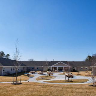 A residential building with a landscaped lawn and clear blue sky.