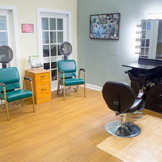 A cozy hair salon interior with styling and drying stations.