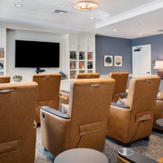 A modern home theater with comfortable recliner chairs and a large TV.