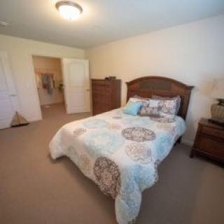 A cozy bedroom with wooden furniture and neatly arranged bedding.