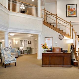A bright and welcoming lobby with a reception desk and staircase.