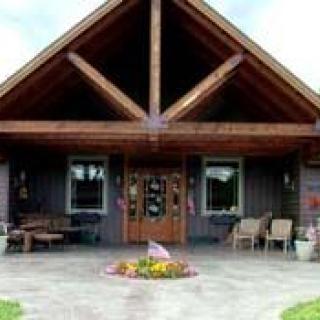 A rustic cabin with a wooden facade and outdoor seating area.