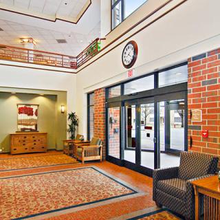 A bright and welcoming lobby with comfortable seating and a large clock on the wall.