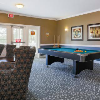 A cozy recreation room featuring a pool table and comfortable seating.