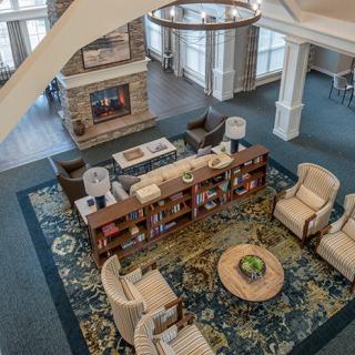 An inviting living room with comfortable seating and a central bookshelf, adorned with a patterned carpet.