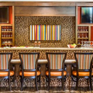 A modern bar interior with striped seating and vibrant decor.