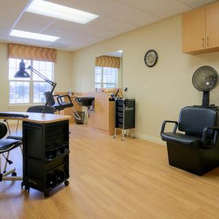 A tidy hair salon interior featuring a workstation, chairs, and styling tools.