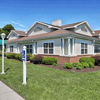 A suburban residential building with a well-maintained lawn and clear blue sky.
