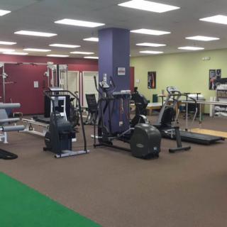 A spacious gym with various exercise equipment including treadmills and weight machines.