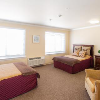 A cozy hotel room with two double beds and soft lighting.