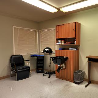 A small hair salon with essential equipment, including a barber chair and washing station.