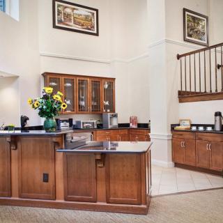 A modern kitchen interior featuring wooden cabinets and a black countertop, adorned with fresh flowers.