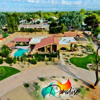 Aerial view of a luxurious resort with a pool and landscaped gardens.