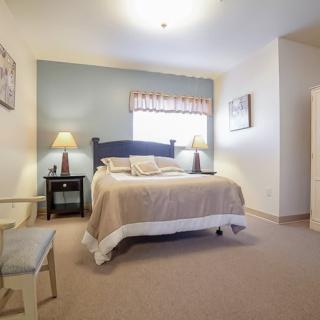 A cozy bedroom with a bed, nightstands, and a window providing natural light.