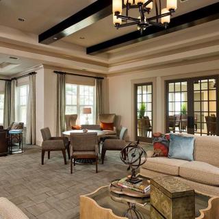 A spacious and elegantly designed living room with comfortable seating and a chandelier.