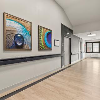 A well-lit hallway featuring vibrant abstract paintings.
