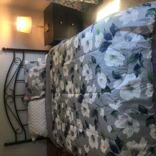 A cozy bedroom with floral bedding and a warm lamp.