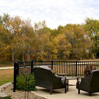 A peaceful patio area with chairs overlooking a scenic view of autumn trees.