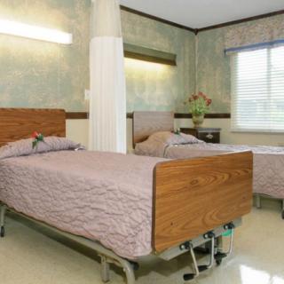 A hospital room with two beds ready for patients.
