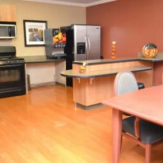 A modern kitchen and dining area with stainless steel appliances and wooden flooring.
