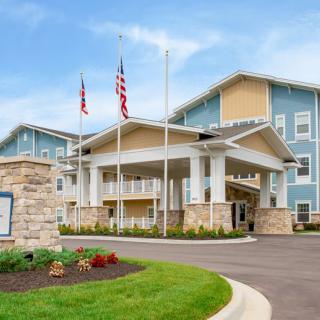 A modern building with flags at the entrance and well-maintained landscaping.