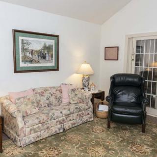 A cozy living room with floral sofa, armchair, and traditional decor.