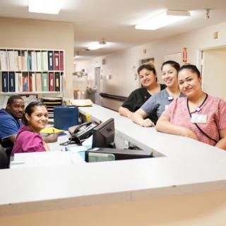 A friendly team of healthcare professionals at the reception desk ready to assist patients.