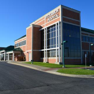 A modern commercial building with large glass windows and brick exterior.
