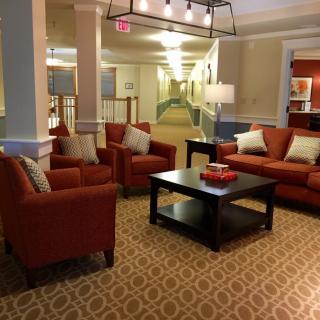 A cozy hotel lobby with red sofas and a central coffee table.