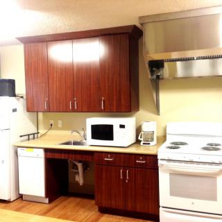 A kitchen with modern appliances and wooden cabinets.
