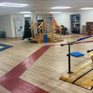 A spacious indoor gym featuring wooden training equipment and a well-defined exercise area.