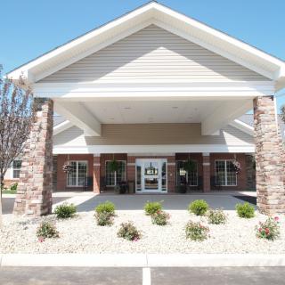 The front entrance of a commercial building with landscaped surroundings.