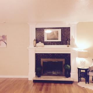 A cozy living room with a central fireplace, adorned with elegant decor and soft lighting.